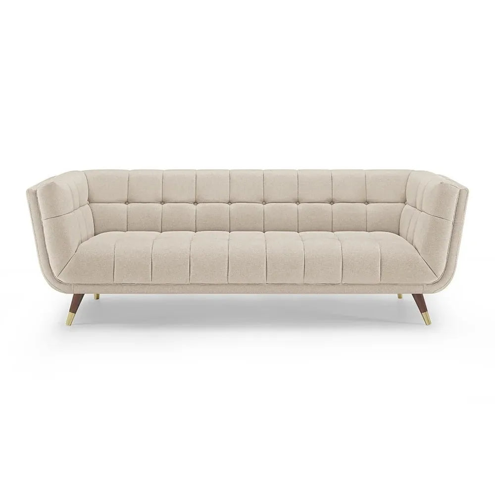 Full frontal view of a light beige three-seater sofa with square tufting, rounded silhouette, and mid-century modern style legs on a white background.