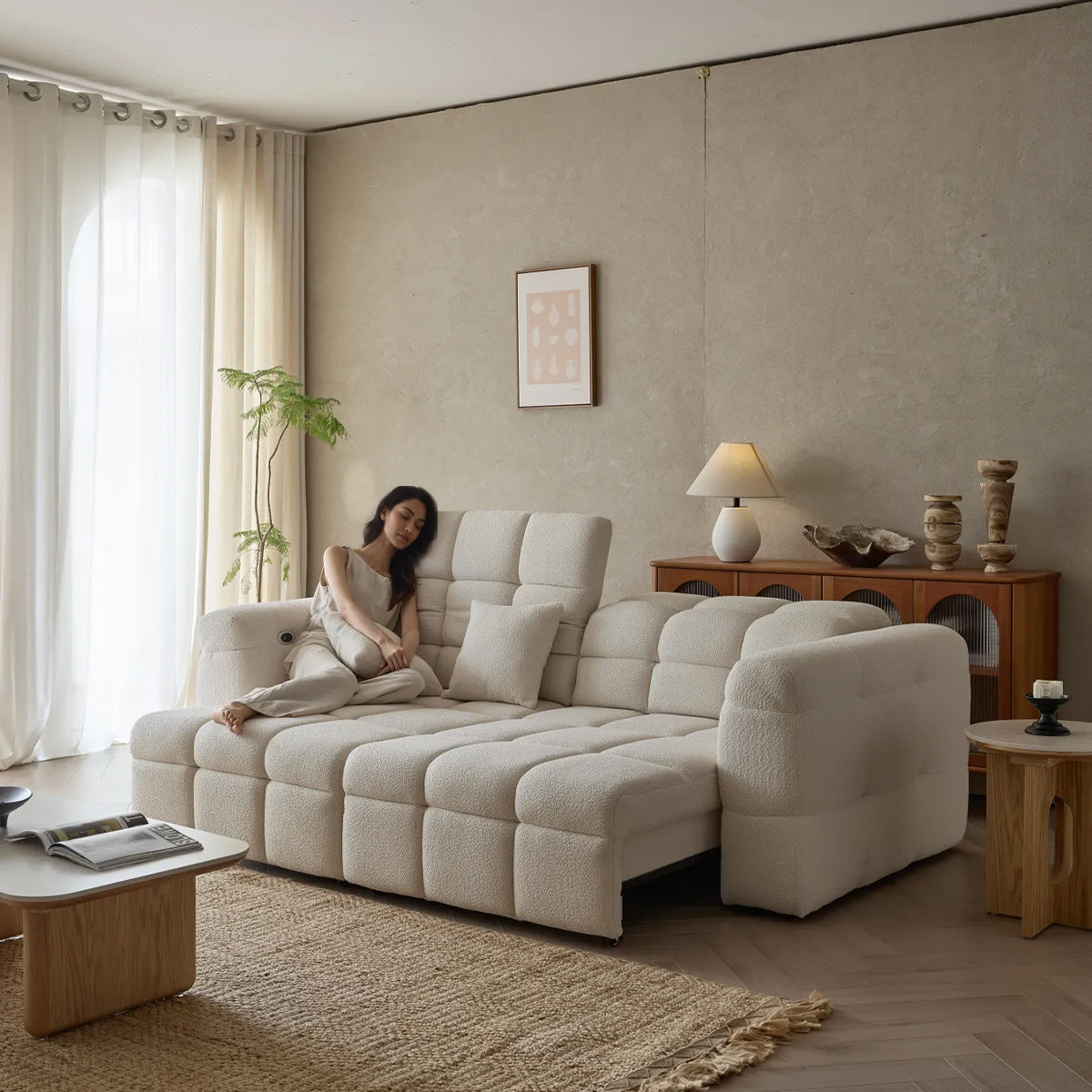 Lennon Cloud Bouclé Sofa Bed extended into a chaise lounge/daybed with a woman relaxing on it.