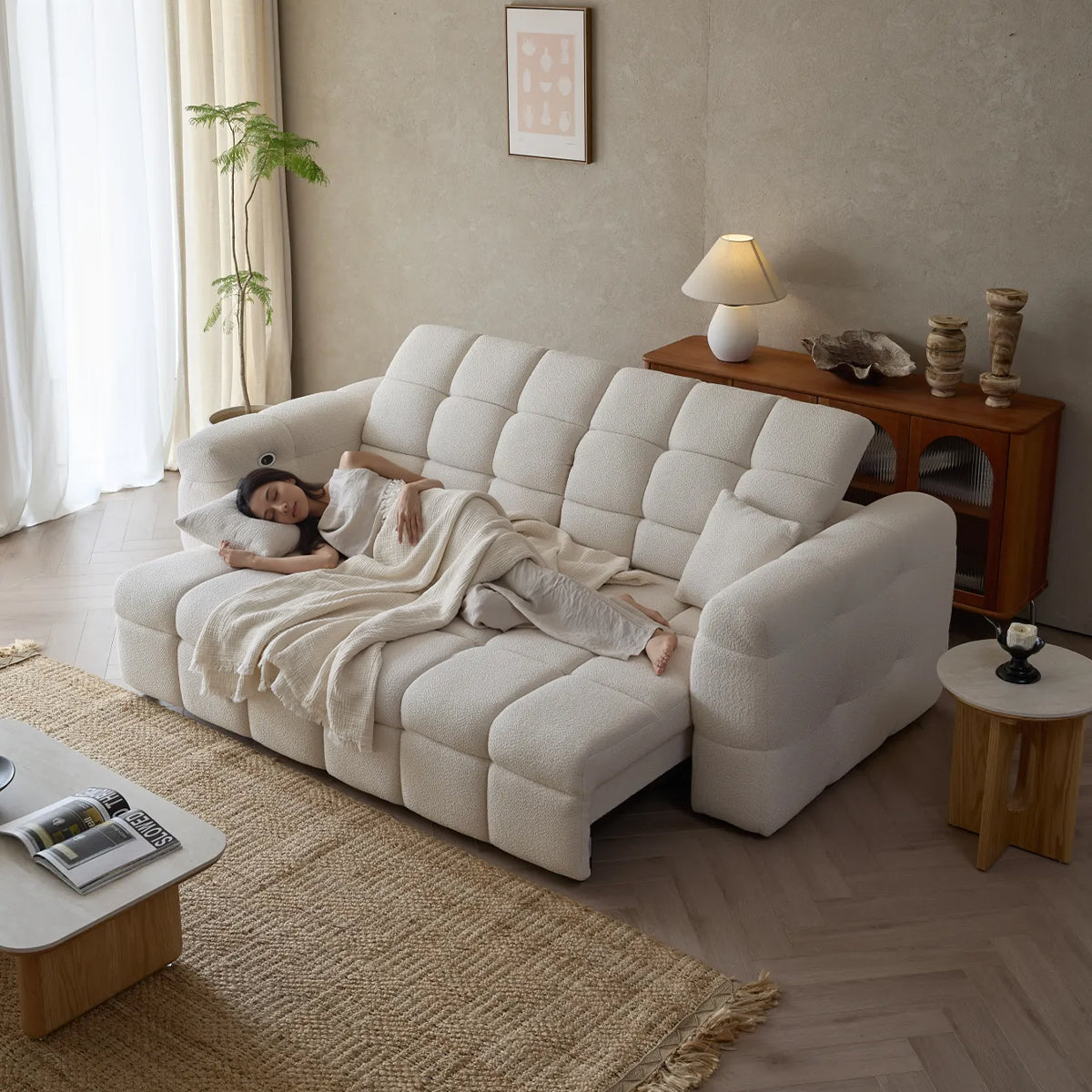 Full extension view of the Lennon Bouclé Sleeper Sofa, showing a woman comfortably sleeping on the fully opened bed.