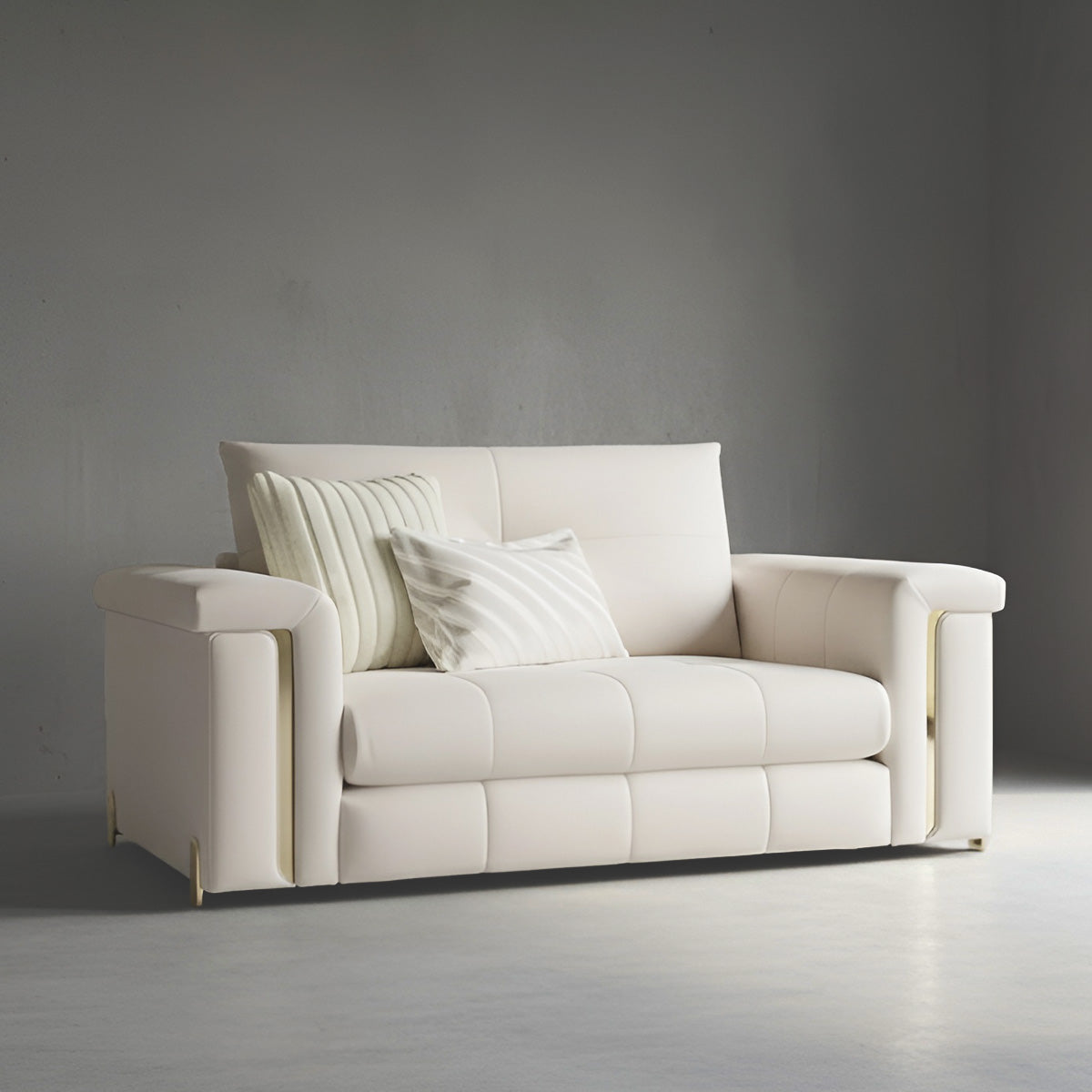 Alcotta 2-seater loveseat in cream fabric featuring gold armrest details and tufted seat cushions.
