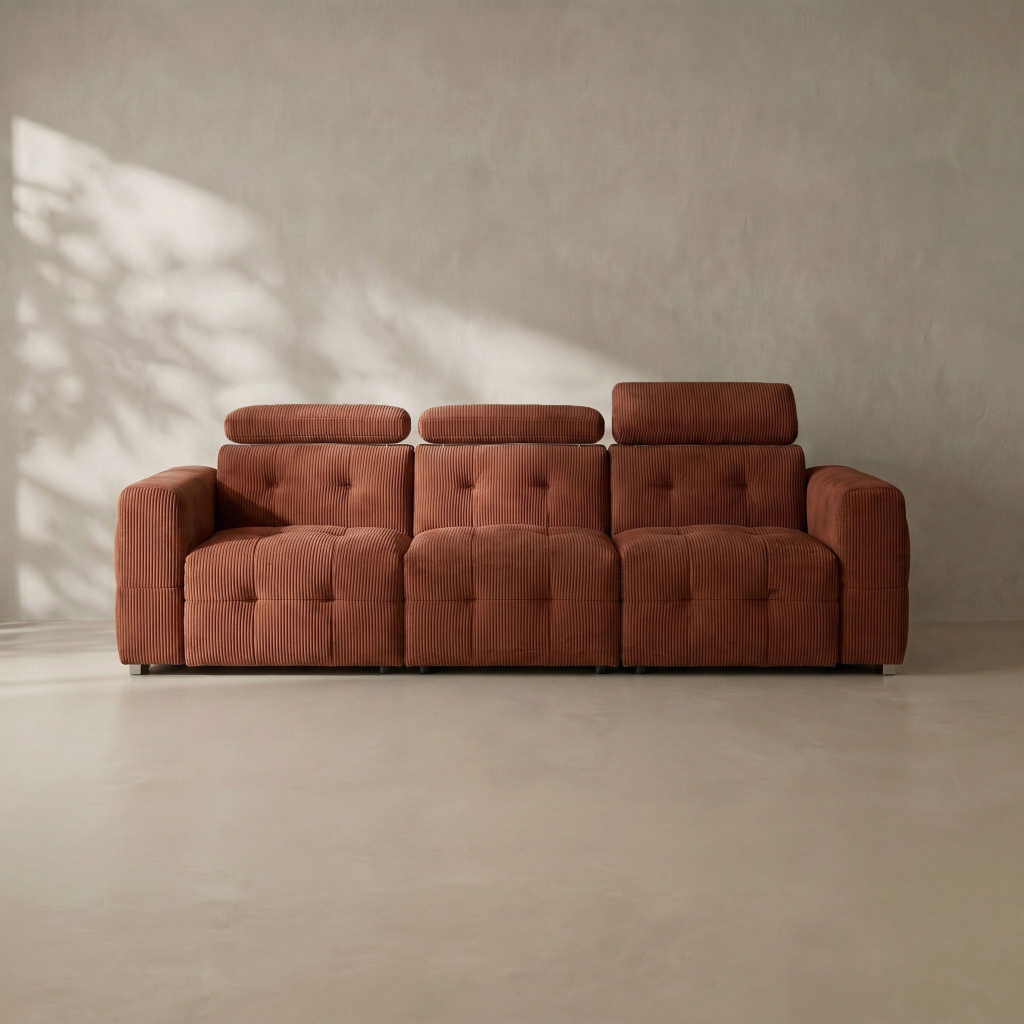 Brown sofa against a beige wall with soft shadows