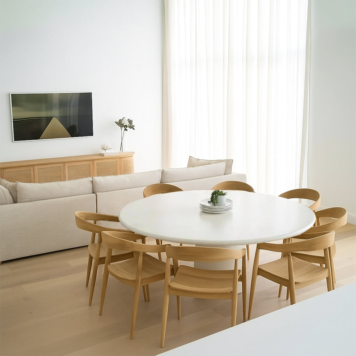 Dining room showing a white round table with eight wooden chairs around it.