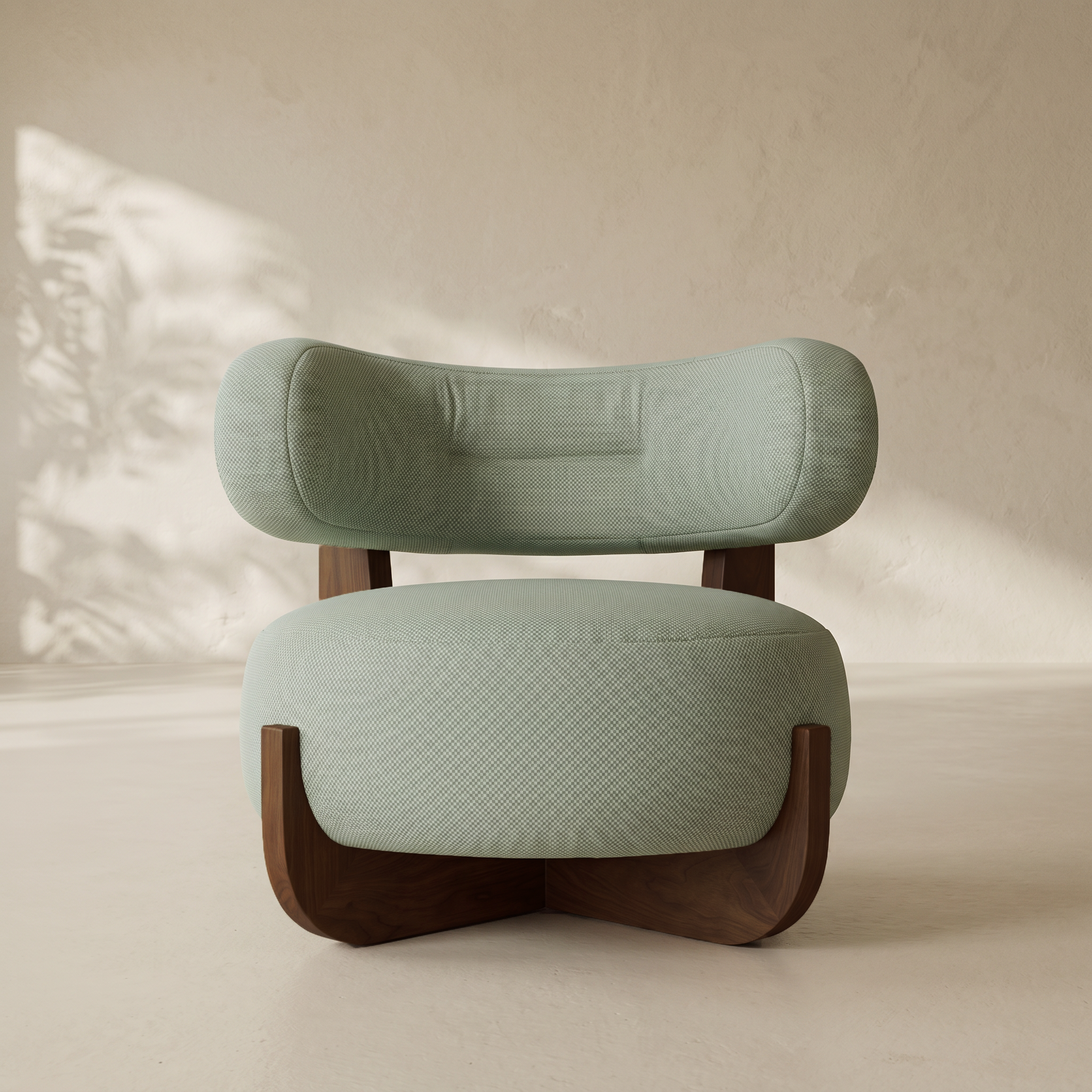 A modern accent chair with a light sage green textured fabric upholstery and dark brown wooden legs, set against a warm beige textured wall with soft leaf shadows.