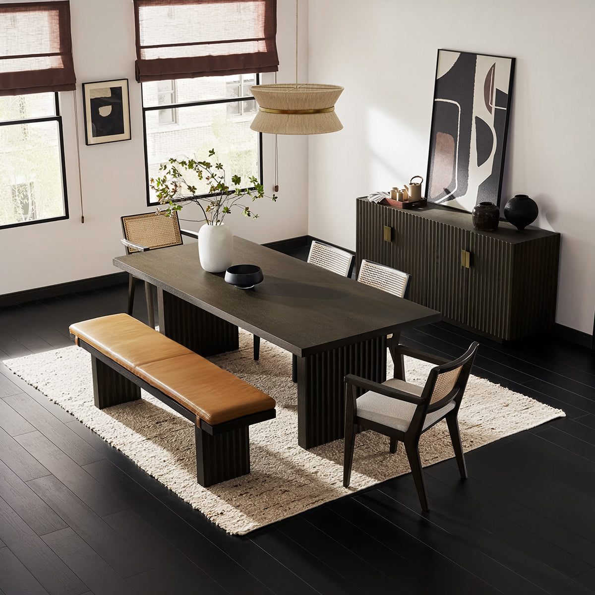 Reede Architectural 6-Seater Dining Set with fluted dark wood table, cane back chairs, and leather bench.