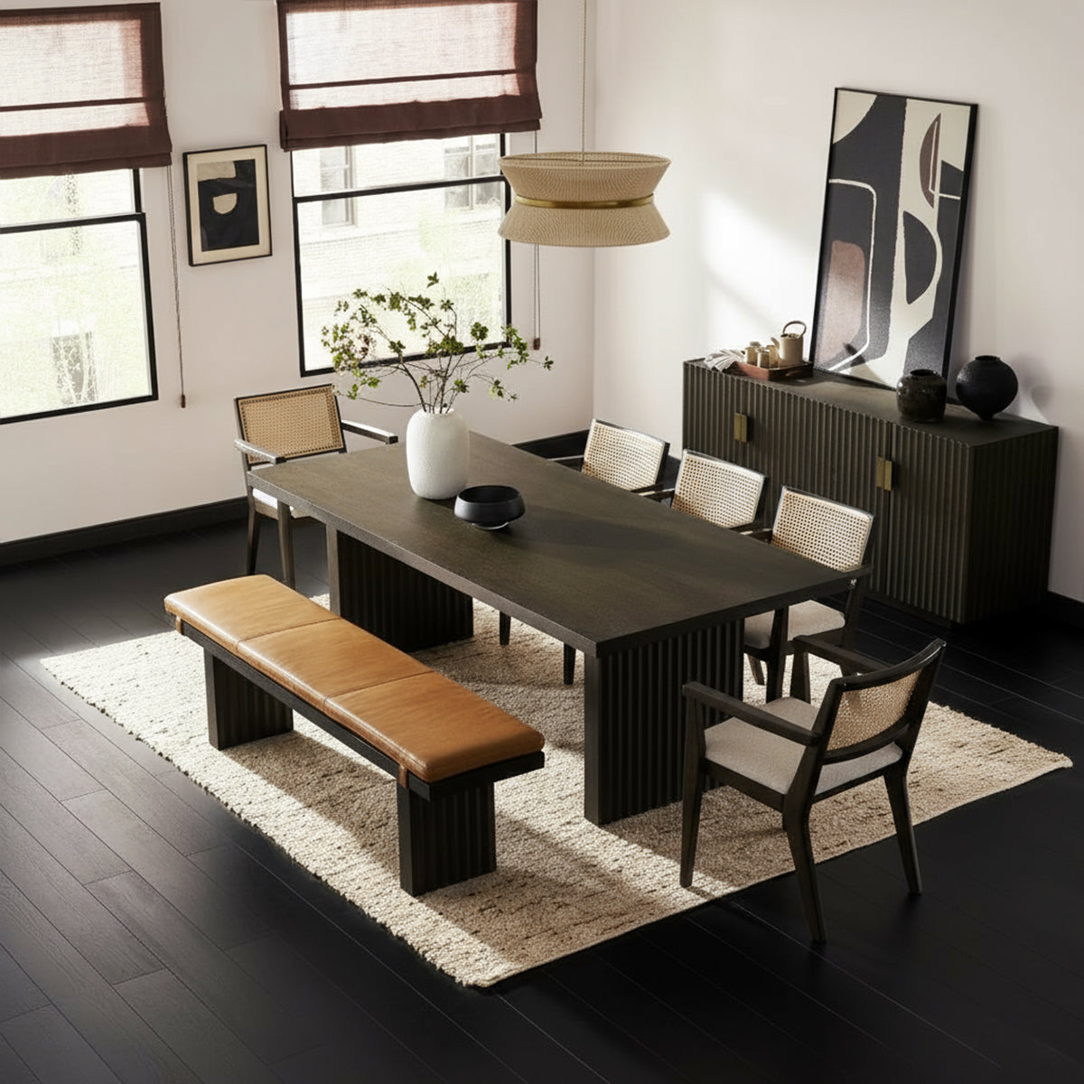 Reede Architectural 8-Seater Dining Table shown with cane chairs and bench in a modern room.