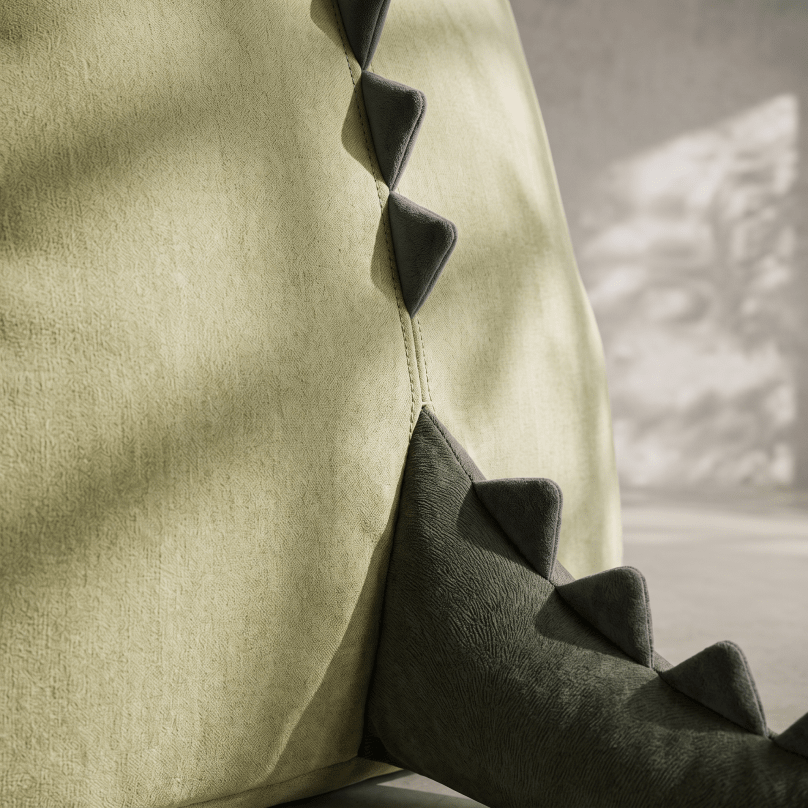 A close-up of a textured sage green fabric surface with a dark olive green faux-leather trim featuring stitched triangular spikes, shown in soft natural light.