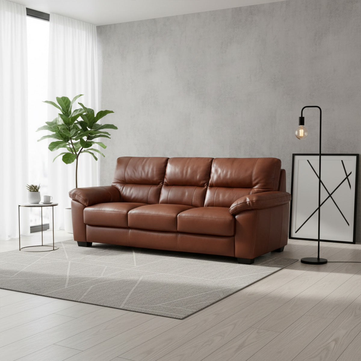 A brown leather 3-seater sofa sits in a bright, modern living space. The room has light hardwood floors, a gray accent wall, a potted plant, and a tall black floor lamp.