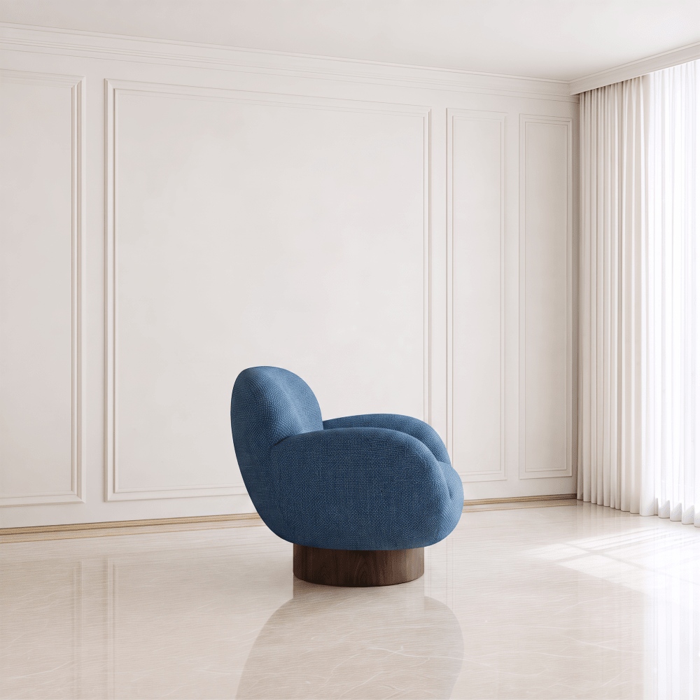 A modern blue upholstered accent chair with a rounded organic silhouette and a dark wood swivel base, set in a minimalist cream-colored room with paneled walls and a tiled floor.