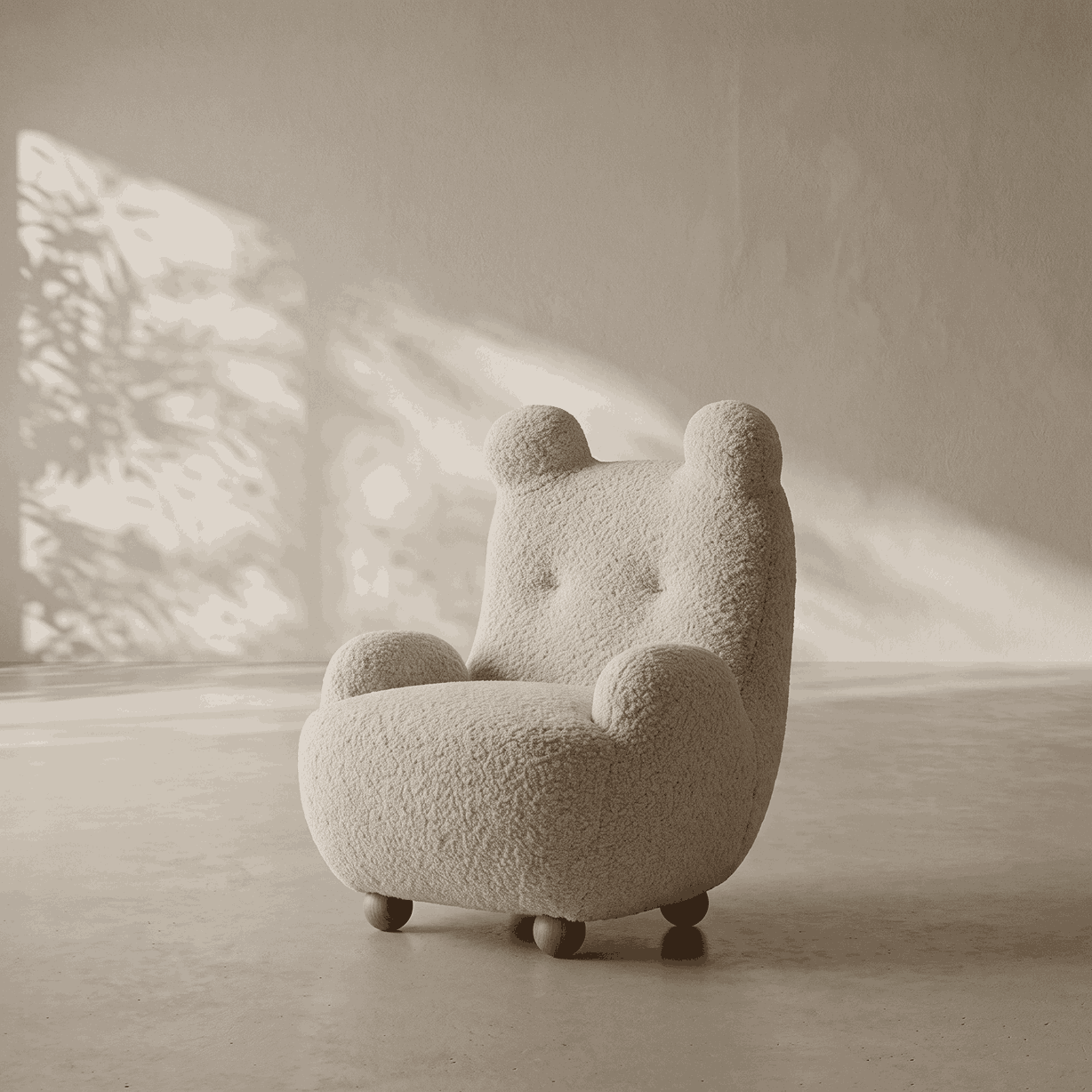 A teddy bear-shaped armchair upholstered in textured cream bouclé fabric, set in a minimalist room with warm sunlight and shadows on a concrete floor.