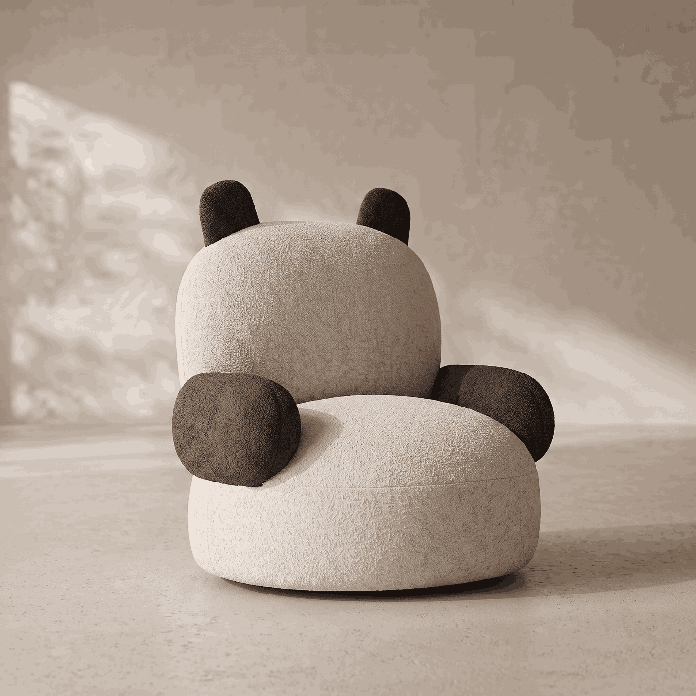 A plush panda-shaped chair upholstered in textured cream fabric with dark brown ears, arms, and feet, shown in a minimalist room setting with soft light and shadow.
