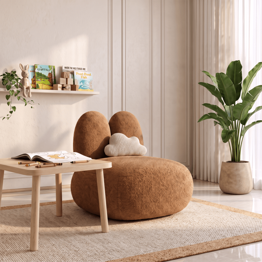 A cozy, rounded lounge chair with a rabbit-ear design upholstered in warm brown fabric, styled in a bright, modern room next to a small wooden table and a potted plant.