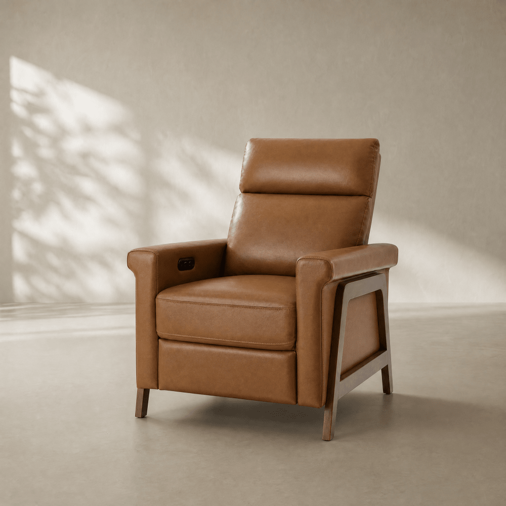 A tan leather recliner chair with a wooden frame, shown in a minimalist room with soft sunlight and leaf shadows on a textured beige wall.