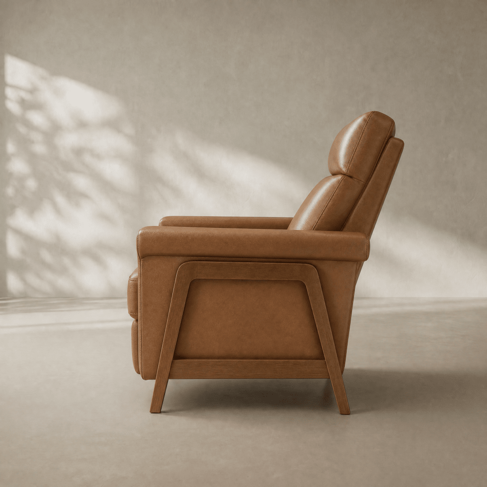 A mid-century modern tan leather recliner chair shown from a side profile against a textured beige wall with soft leaf shadows.