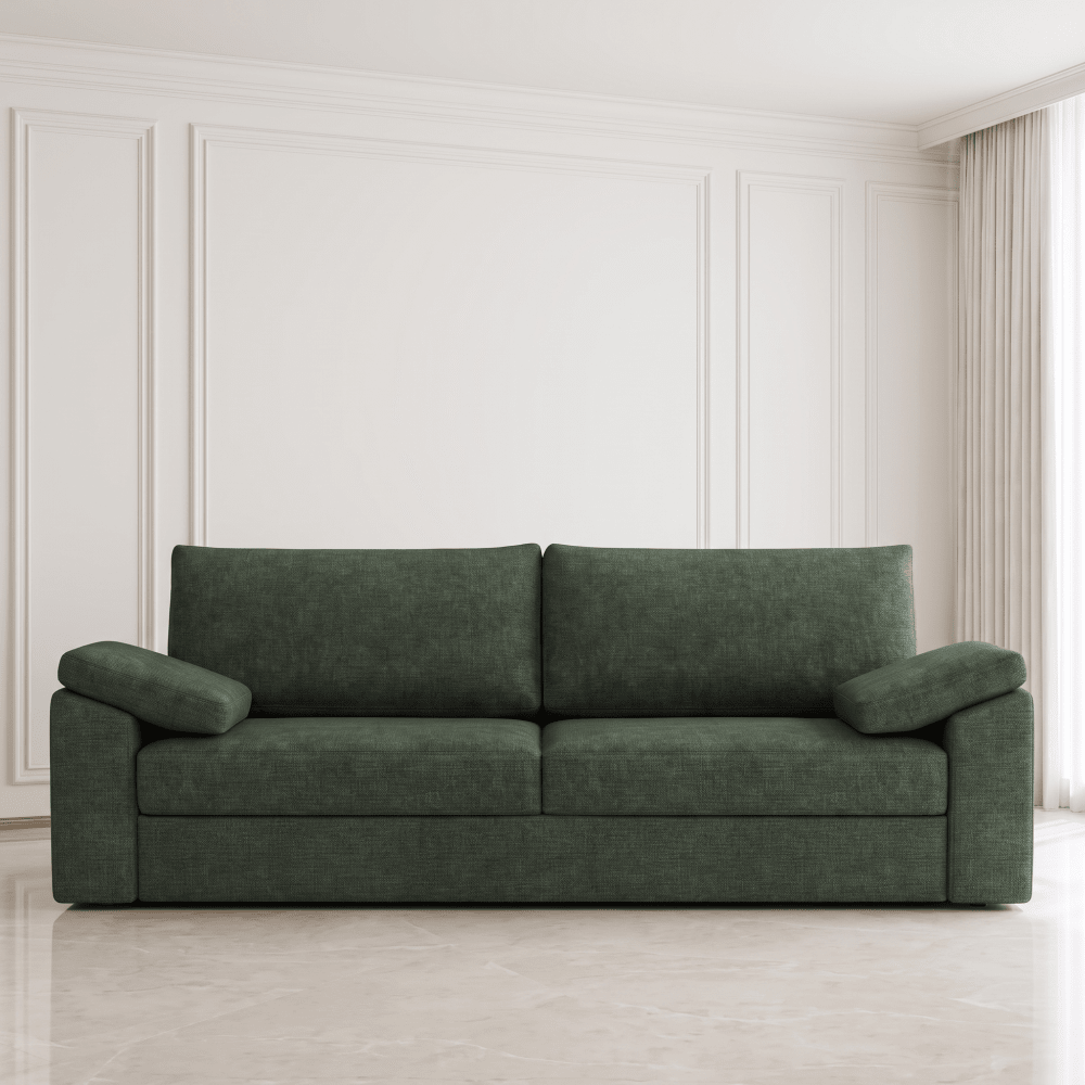 A dark green upholstered loveseat sofa centered against a white paneled wall with a light marble floor and beige curtains.