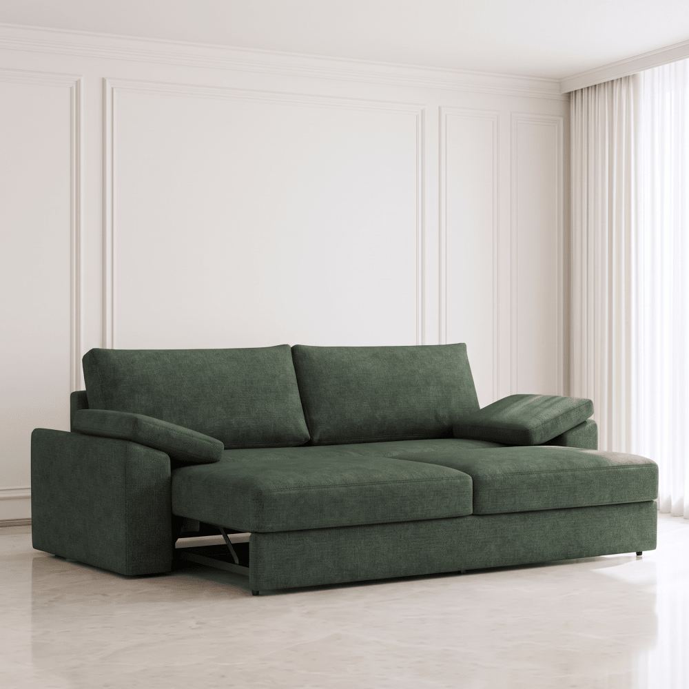 A dark green fabric sofa bed with a chaise lounge on the left, shown in a bright, modern room with white paneled walls and light-colored flooring.