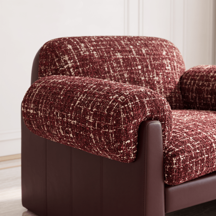 A close-up of a modern armchair with textured burgundy and cream woven upholstery on the seat, backrest, and arm cushions, supported by a dark brown paneled frame.