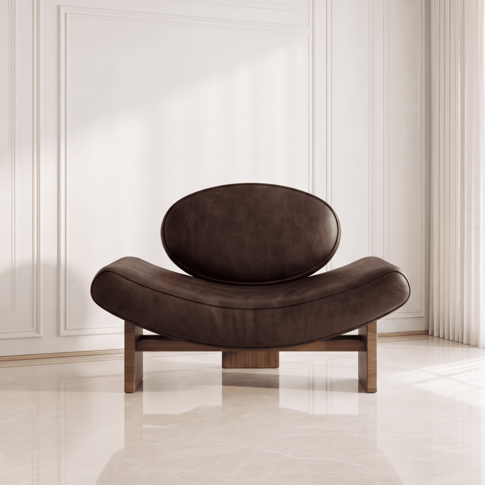 A modern curved lounge chair with dark brown leather upholstery and a wooden base, set against a minimalist white paneled wall and light marble floor.